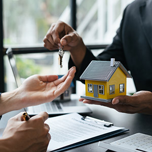 Real estate broker residential house giving house keys to his customer after the deal was done.